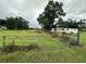 View of a yard with grass, a fence, and a white mobile home at 1886 Pleasant Hill Rd, Kissimmee, FL 34746
