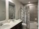 The bathroom features a double sink vanity and a shower/tub combination with stylish Parisian-themed shower curtain at 1896 Basenji Dr, Lake Alfred, FL 33850