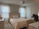 Bright bedroom features a bed with a white wood frame and plush blanket, complemented by sheer curtains at 1896 Basenji Dr, Lake Alfred, FL 33850