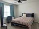 Bedroom with a modern bed frame, a ceiling fan, and a desk near a window with teal curtains at 1896 Basenji Dr, Lake Alfred, FL 33850