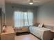 Bright bedroom features a ceiling fan, tiled floor, and large window with natural light at 1896 Basenji Dr, Lake Alfred, FL 33850