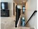 Upper hallway overlooking the staircase and the entryway featuring neutral walls and black railings at 1896 Basenji Dr, Lake Alfred, FL 33850