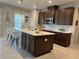Modern kitchen with dark cabinets, a large island, and updated appliances at 1896 Basenji Dr, Lake Alfred, FL 33850