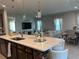Open concept view of the kitchen island, dining area, and living room, perfect for entertaining at 1896 Basenji Dr, Lake Alfred, FL 33850
