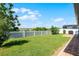Well-maintained backyard with a white picket fence, green lawn, and mature trees at 1951 Partin Terrace Rd, Kissimmee, FL 34744