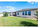 Wide view of the backyard, showcasing a covered patio, lush lawn, and the home's exterior at 1951 Partin Terrace Rd, Kissimmee, FL 34744