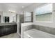 Bright bathroom showcasing a soaking tub, walk-in shower, and vanity with granite countertop at 1951 Partin Terrace Rd, Kissimmee, FL 34744
