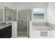 Bright bathroom featuring soaking tub, walk-in shower, and vanity with granite countertop at 1951 Partin Terrace Rd, Kissimmee, FL 34744