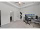 Spacious bedroom featuring carpet flooring, a ceiling fan, and an adjacent bathroom and open doorway at 1951 Partin Terrace Rd, Kissimmee, FL 34744