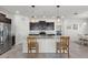 Kitchen with breakfast bar, stainless steel refrigerator, tile floors, and dark cabinetry at 1951 Partin Terrace Rd, Kissimmee, FL 34744