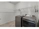 Modern laundry room with gray washer and dryer and ample shelving for storage at 1951 Partin Terrace Rd, Kissimmee, FL 34744