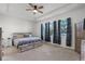 Comfortable main bedroom with carpet, tray ceiling, ceiling fan, and multiple windows at 1951 Partin Terrace Rd, Kissimmee, FL 34744
