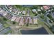 Aerial view of a residential area with well-maintained houses, lush greenery, and a scenic pond at 2016 Lakeside Ave, Davenport, FL 33837