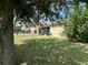 View of the backyard featuring a screened-in porch, green lawn, and shady trees at 2016 Lakeside Ave, Davenport, FL 33837