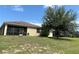 View of the backyard featuring a screened-in porch, green lawn, and mature trees offering shade at 2016 Lakeside Ave, Davenport, FL 33837