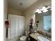 A bathroom featuring a granite vanity top, a toilet, and a shower tub with a shower curtain at 2016 Lakeside Ave, Davenport, FL 33837