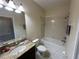 Bathroom features a shower over tub combination, granite countertop, and tile flooring at 2016 Lakeside Ave, Davenport, FL 33837