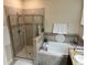 Bathroom featuring a shower with glass door and a soaking tub with decorative tile surround at 2016 Lakeside Ave, Davenport, FL 33837