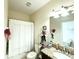 Bathroom features a granite countertop, white cabinets and combination tub and shower at 2016 Lakeside Ave, Davenport, FL 33837