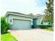 Charming single-Gathering home features a gray 2-car garage, clay tile roof, and brick driveway at 2016 Lakeside Ave, Davenport, FL 33837