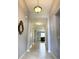 View of the tiled hallway in a home with gray walls and decorative mirror at 2016 Lakeside Ave, Davenport, FL 33837