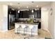 Modern kitchen features dark cabinetry, stainless steel appliances, and an island with bar seating at 2016 Lakeside Ave, Davenport, FL 33837