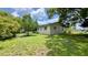 Side view of the home featuring a grass yard and mature trees at 2127 Patrick St, Kissimmee, FL 34741