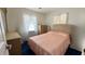 Traditional bedroom with a pink bedspread, wooden dresser, and bright windows at 2127 Patrick St, Kissimmee, FL 34741