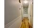 Hallway with wood floors, white molding, and neutral-colored walls at 2127 Patrick St, Kissimmee, FL 34741
