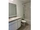 Well-lit bathroom featuring a shower-tub combo, a large mirror, and a white vanity with a sink at 254 Mandovi St, Davenport, FL 33837