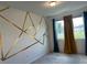 Modern bedroom featuring carpet, gold geometric wall decor, and dual-color curtains at 254 Mandovi St, Davenport, FL 33837