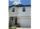 Charming two-story home with a white garage door, a dark brown entry door, and a manicured lawn at 254 Mandovi St, Davenport, FL 33837