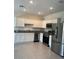 Modern kitchen with white cabinets, stainless steel appliances, and tile flooring at 254 Mandovi St, Davenport, FL 33837