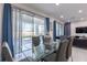 Bright dining room features a glass table, modern chairs, and sliding glass doors leading to the outdoor space at 2623 Calistoga Ave, Kissimmee, FL 34741