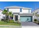 Inviting two-story home with a well-manicured lawn, palm trees, and a driveway with a two-car garage at 2623 Calistoga Ave, Kissimmee, FL 34741