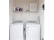 Efficient laundry room with a white washer and dryer, and upper shelving at 2623 Calistoga Ave, Kissimmee, FL 34741