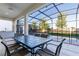 Covered patio with dining table and chairs overlooking the pool and lanai with its screened enclosure at 2623 Calistoga Ave, Kissimmee, FL 34741