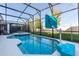Lanai enclosed in screen with a pool and jacuzzi, grassy backyard, and basketball hoop at 2623 Calistoga Ave, Kissimmee, FL 34741