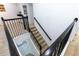 Carpeted staircase with dark railing and white walls provide access to the upper level of the home at 2623 Calistoga Ave, Kissimmee, FL 34741