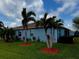 Exterior view of the blue single-story home with well-maintained lawn and palm trees at 2919 Woodward Ln, Winter Haven, FL 33884