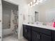 Bathroom with double sink vanity, dark cabinets, and shower with patterned curtain at 3052 Prelude Ln, Kissimmee, FL 34746