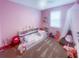Pink-themed bedroom featuring a cozy bed, shelving, and stuffed animals, offering a playful atmosphere at 3052 Prelude Ln, Kissimmee, FL 34746