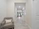 Inviting hallway with neutral walls, tile floors, and an accent chair at 3052 Prelude Ln, Kissimmee, FL 34746