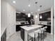 Modern kitchen features an island with bar stools, stainless steel appliances, and tile floors at 3052 Prelude Ln, Kissimmee, FL 34746