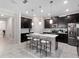 Modern kitchen boasts an island with bar stools, sleek black cabinetry, and tile floors at 3052 Prelude Ln, Kissimmee, FL 34746