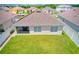 Aerial backyard view of home with a screened patio and green lawn at 3062 Royal Tern Dr, Winter Haven, FL 33881