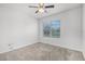 Bright carpeted bedroom featuring a window overlooking a well-manicured yard at 3062 Royal Tern Dr, Winter Haven, FL 33881