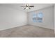 Cozy bedroom with neutral carpet, ceiling fan, and a window offering natural light and a calm ambiance at 3062 Royal Tern Dr, Winter Haven, FL 33881