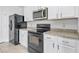 Close up of the kitchen with stainless steel appliances, granite countertops, and white cabinets at 3062 Royal Tern Dr, Winter Haven, FL 33881