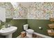 Charming half bathroom with floral wallpaper, a pedestal sink, and stylish decor at 3224 Oxbow Ct, Harmony, FL 34773